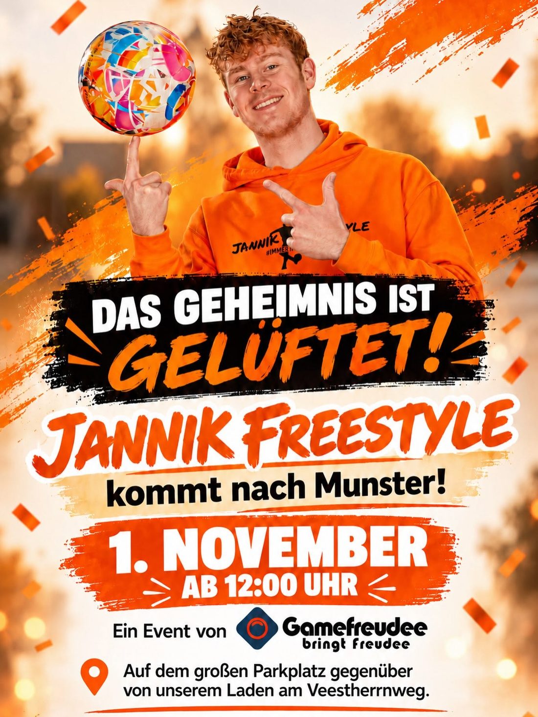Plakat: Das Geheimnis ist gelüftet! Jannik Freestyle kommt nach Munster! 1. November, ab 12:00 Uhr. Ein Event von Gamefreudee – bringt freudee. Auf dem großen Parkplatz gegenüber von unserem Laden am Veestherrnweg. Im Bild: Jannik Freestyle im orangefarbenen Hoodie lässt einen bunten Ball auf dem Finger kreisen. Mit KI bearbeitet.